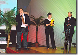 David Meltzer - Singing a medley of 43 different national anthems (first couple of lines only) during the opening ceremony of the 2004 World Masters Weightlifting Championships, Baden, Austria, September 25, 2004. The flag bearers of the teams are marching into the hall, and are visible on the projection screen in the background